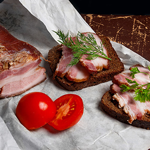 Smoked bacon with rye black bread and tomatoes