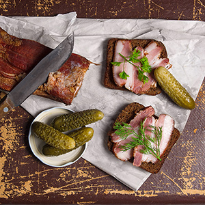 Smoked bacon with rye black bread and several pickles
