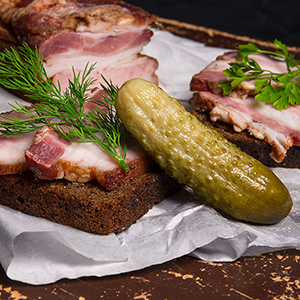 Smoked bacon with rye black bread and several pickles