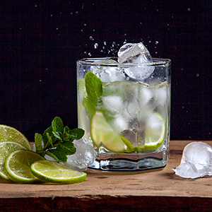 Summer cocktail mojito in glass, sliced lime and mint
