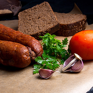 Slices of smoked sausage with spice, herbs and vegetables